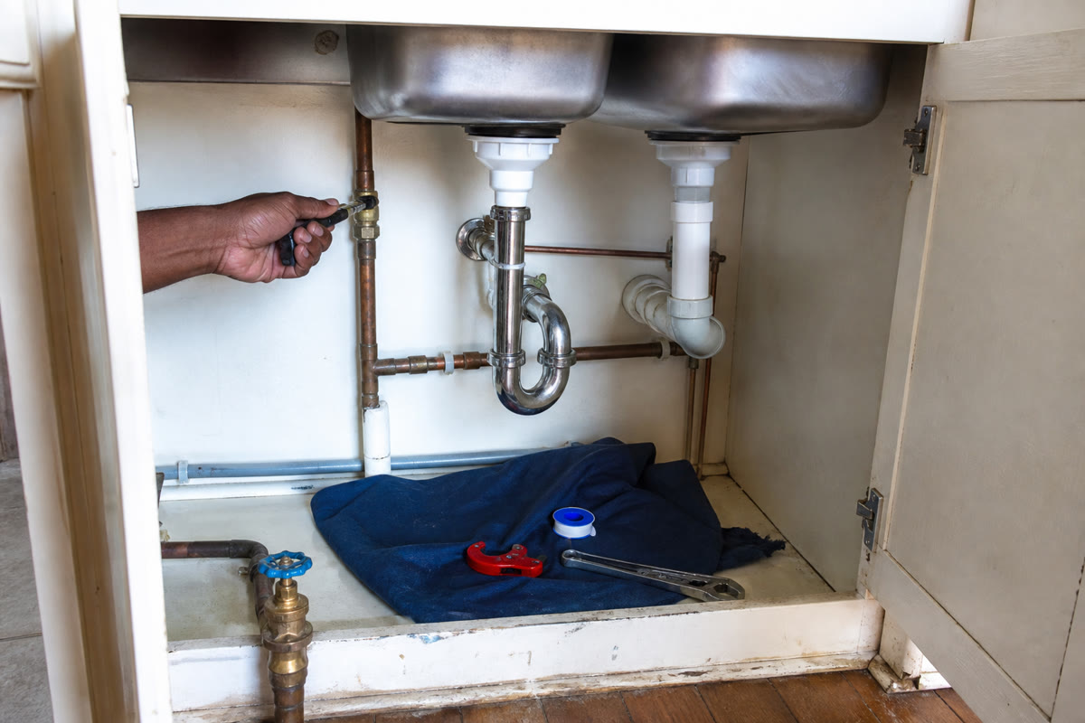 Kitchen sink cabinet with copper fittings, a P-trap and isolation work in progress